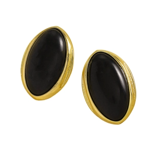 Close-up detail of vintage oval black resin stud earrings with gold-toned metal trim