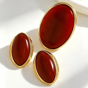 Detailed view of vintage oval dark red resin earrings set in elegant gold metal frames