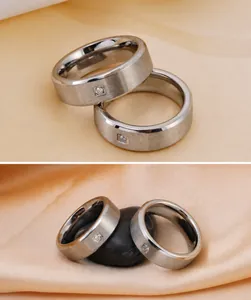 Detailed close-up of pair of silver titanium rings featuring brushed finish and small inset diamond