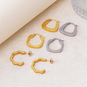 Dettagli di orecchini a cerchio geometrici con finiture opache oro e argento