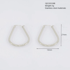 Detailed macro view of silver stainless steel earrings with hammer texture finish
