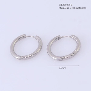 Detailed view of silver stainless steel hoop earrings with hammered texture and 26mm diameter