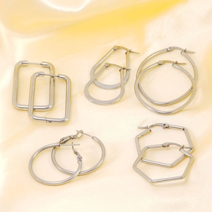Set of five geometric silver titanium steel hoop earrings on yellow silk fabric