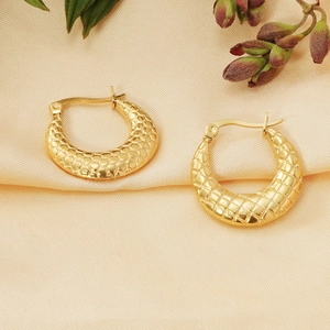 Detailed macro view of 18K gold-plated earrings with a geometric honeycomb pattern