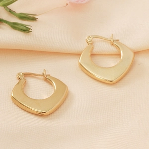 Detail shot of geometric shield earrings in 18K gold plated stainless steel finish