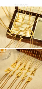 Detail of 18K gold-plated stainless steel initial pendants with brushed texture finish