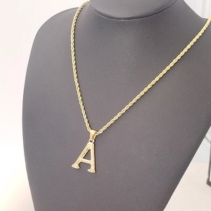 Detail of 18K gold-plated rope chain necklace with hammered texture A-letter pendant