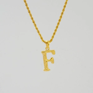 Detail of 18K gold-plated stainless steel letter F pendant with tree bark texture