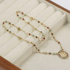 Collana in acciaio dorato con pietre di zircone colorate e medaglia religiosa incisa