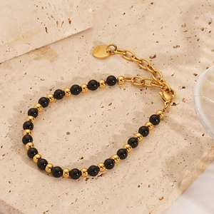 Detail view of gold 18K stainless steel beads and black natural stone on the bracelet