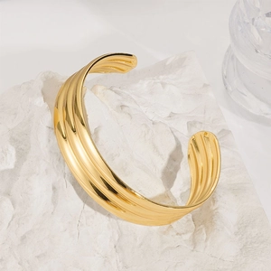 Detail view of gold-plated stainless steel cuff with unique pleated wave texture