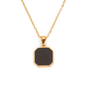 Macro shot of gold square pendant necklace with black agate stone in vintage frame