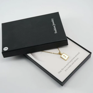 Goldene J-Buchstabenkette mit weißer Einlage in einer schwarzen Geschenkbox