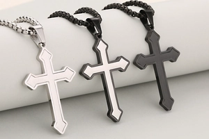 Detalle de colgantes de cruz de flecha de acero inoxidable en plata, bicolor y negro