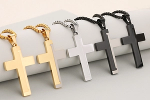 Five styles of two-tone stainless steel cross pendants with textured diagonal patterns