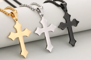 Detailansicht religiöser gotischer Kreuzanhänger in Gold, Silber und schwarzem Edelstahl