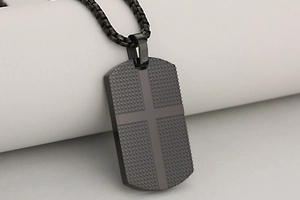 Macro shot of black dog tag necklace with cross pattern and anti-slip grid texture
