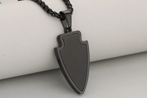 Gros plan du pendentif bouclier noir plaqué or 18K avec texture brossée et chaîne