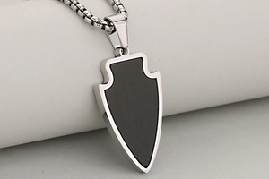 Détail du pendentif bouclier avec incrustation noir mat et chaîne box en acier argenté
