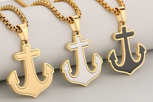 Detalle de collares con colgante de ancla en oro, plata y negro con cadena de caja
