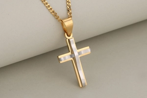Macro detail of a double-layered gold and silver stainless steel cross pendant necklace