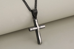 Macro shot of double-layered cross pendant in black and silver polished stainless steel