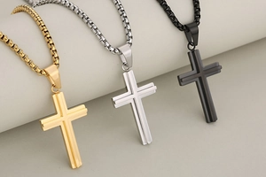 Detail view of cross necklaces in gold, silver, and black with polished box chains