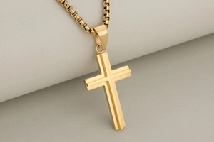 Detailed close-up of double-layered gold stainless steel cross pendant with box chain