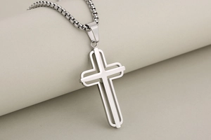 Detailed close-up of a silver hollow cross pendant with mirror-polished box chain