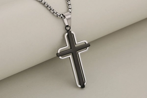 Close-up of double-layered stainless steel cross pendant with black overlay and box chain