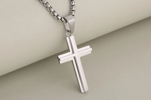Macro shot of silver layered stainless steel cross pendant with round box chain link