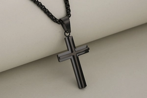 Detail of minimalist black stainless steel double-layered cross pendant and box chain