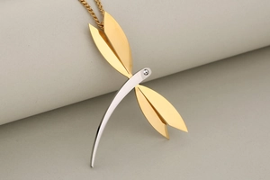 Detail of dragonfly pendant with gold wings, silver body and clear zircon stone