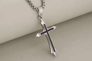 Detailed close-up of a double-layered brushed stainless steel cross with black enamel finish