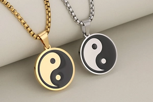 Close-up of gold and silver stainless steel Yin Yang pendants with sleek box chains
