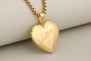 Detailed macro view of a polished golden heart-shaped love locket with a hinge structure