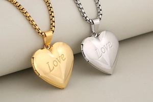 Detail of heart-shaped locket necklaces with Love engraving in gold and silver finish