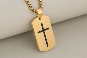 Close-up of golden stainless steel cross pendant featuring a brushed metal texture