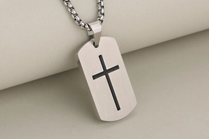Detailed close-up of a brushed stainless steel military tag pendant with black cross