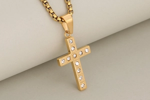 Macro shot of gold stainless steel cross pendant necklace with sparkling zircon stones