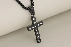 Detailed view of a black stainless steel cross pendant featuring 11 sparkling crystals