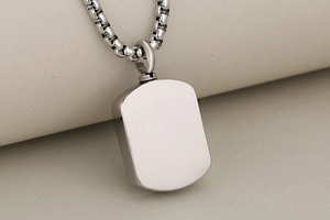 Macro shot of stainless steel rectangle urn pendant with threaded screw top for ashes