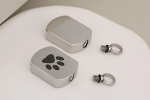 Detail view of screw-top stainless steel pet urn pendants showing components and seal