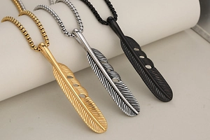 Detailed close-up of feather pendant necklaces in gold, silver, and matte black finish