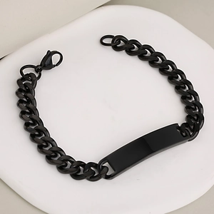 Black stainless steel Cuban link bracelet with a blank polished ID tag on a white tray