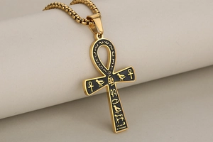 Close-up of golden stainless steel Ankh pendant with black enamel Egyptian hieroglyphs
