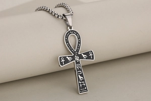 Macro view of stainless steel Ankh cross pendant with black enamel and Egyptian symbols