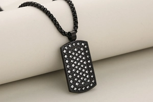 Macro detail of black plated hip hop dog tag pendant with iced out cubic zirconia