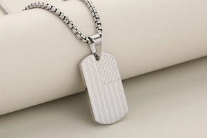 Detailed view of stainless steel military dog tag pendant with American flag engraving
