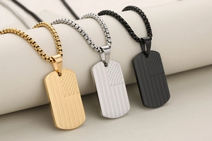 Detailed shot of rectangle dog tag pendants in gold, silver and matte black with US flag